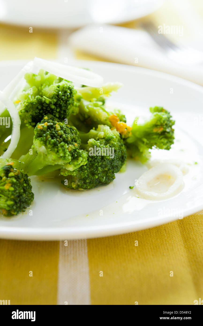 Stufati di pezzi di broccoli su un piatto bianco, primo piano Foto Stock