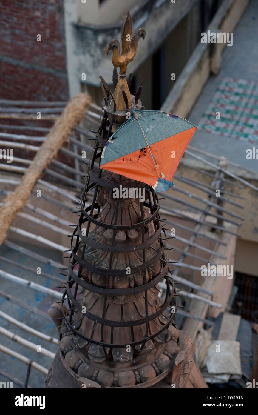 Un aquilone di carta, catturato sulla guglia di un tempio di Varanasi (India). Foto Stock