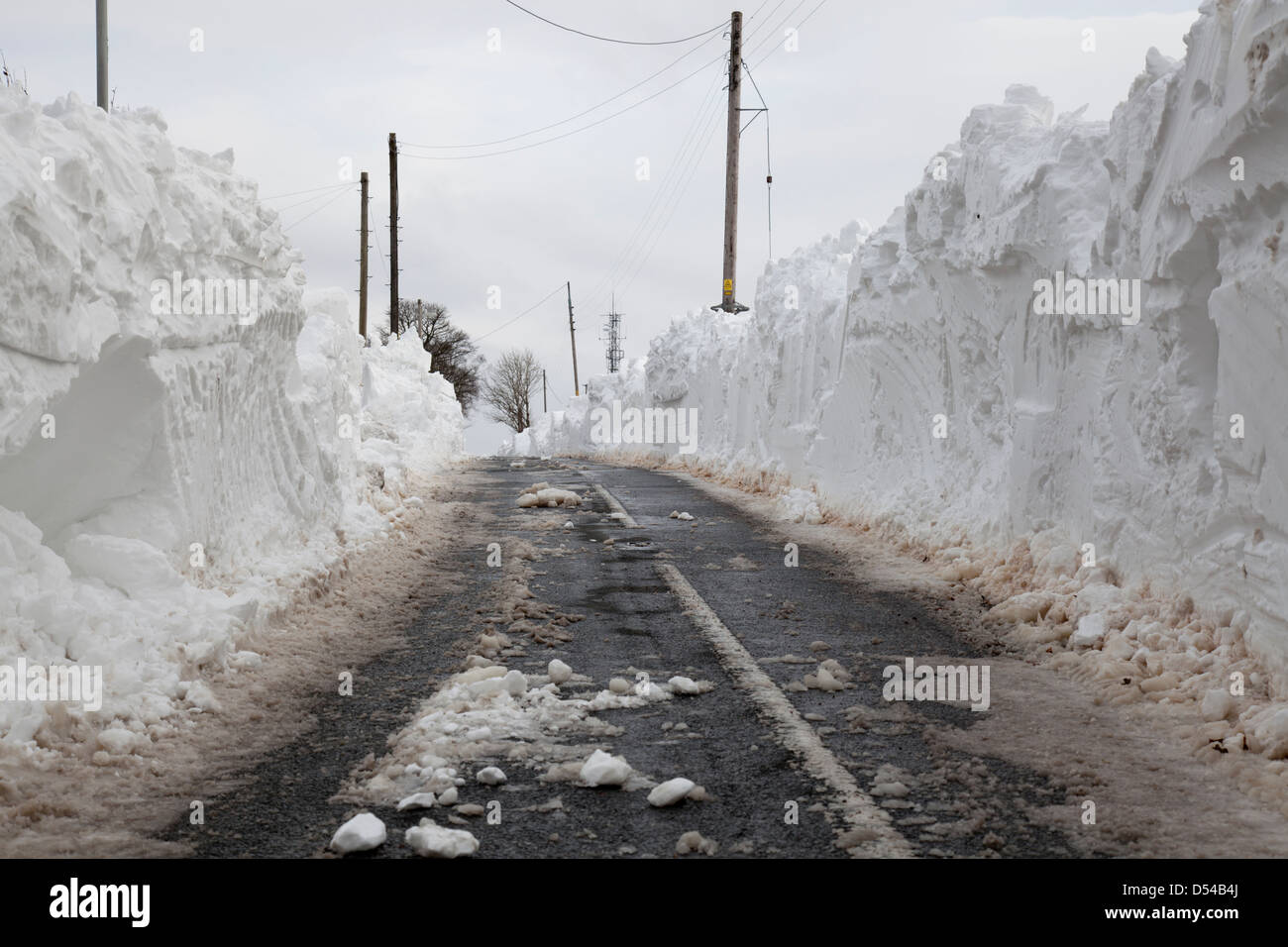 Un canale tagliato attraverso la neve profonda derive per aprire una corsia in Lancashire Foto Stock