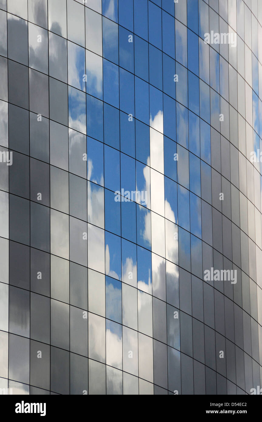 Il lato di un edificio per uffici realizzati in vetro riflettente con cielo blu Foto Stock