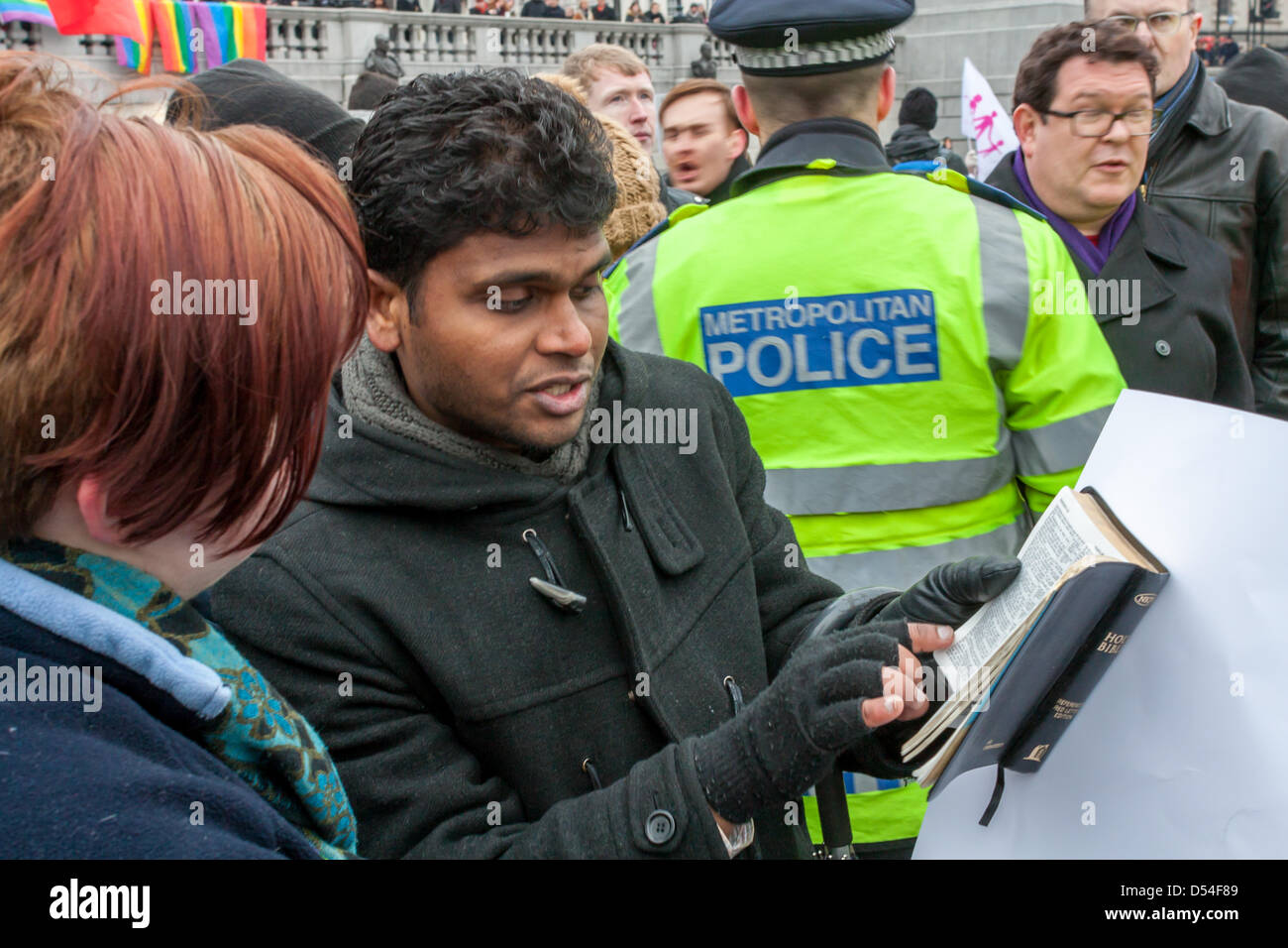 Un cristiano legge estratti della bibbia ad un i diritti LGBT sostenitore. Manifestanti su entrambi i lati dell'argomento sul matrimonio uguaglianza riuniti in Trafalgar Square a Londra. Il 24 marzo 2013. Gli organizzatori della protesta La Manif Pour Tous si svolge a Parigi aveva organizzato una simultanea di eventi di Londra. Un contatore dimostrazioni era stato organizzato da i diritti LGBT sostenitori. Foto Stock