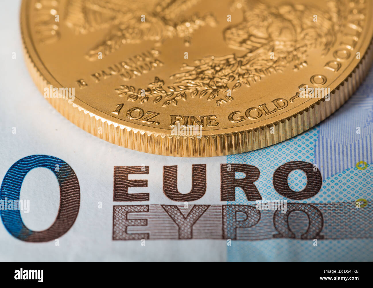 Oro massiccio monete contrastato con euro notesuggesting problemi di debito in Europa Foto Stock
