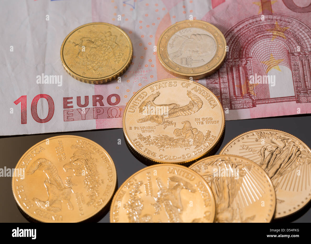 Oro massiccio monete contrastato con nota di Euro monete e suggerendo i problemi di debito in Europa Foto Stock