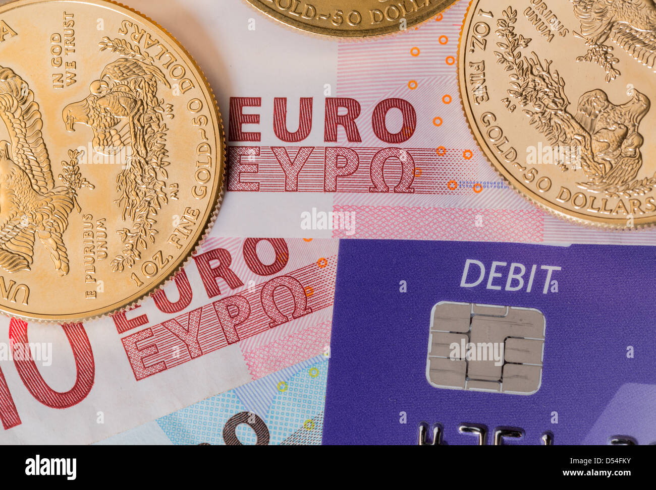 Oro massiccio monete in contrasto con la parola di addebito su carta plastica su euro nota proponendo problemi di debito Foto Stock