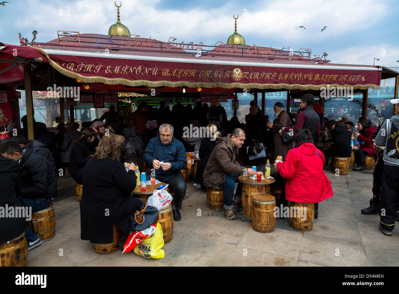 Persone mangiare pesce e pane (balik ekmek) a Eminou Harbourside Istanbul Turchia Foto Stock