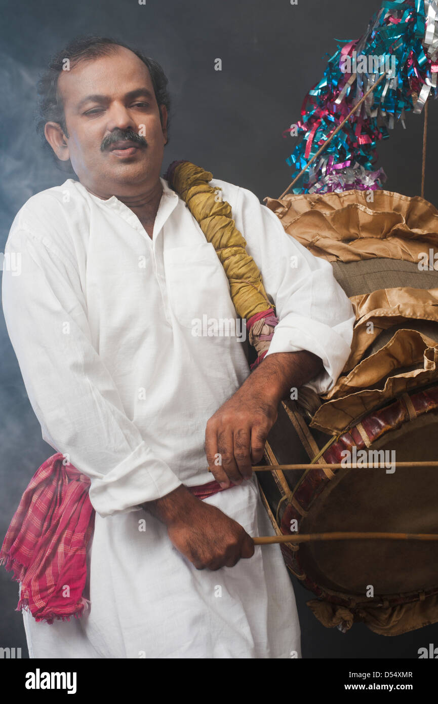 Uomo in Bengali giocando dhol (un grande tamburo utilizzato per riprodurre durante il festival e celebrazione in India) Foto Stock
