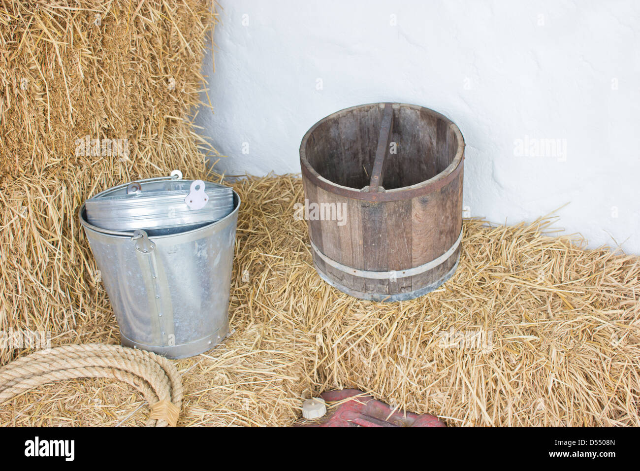 Benna metallico e secchio di legno sul riso di fieno. Foto Stock