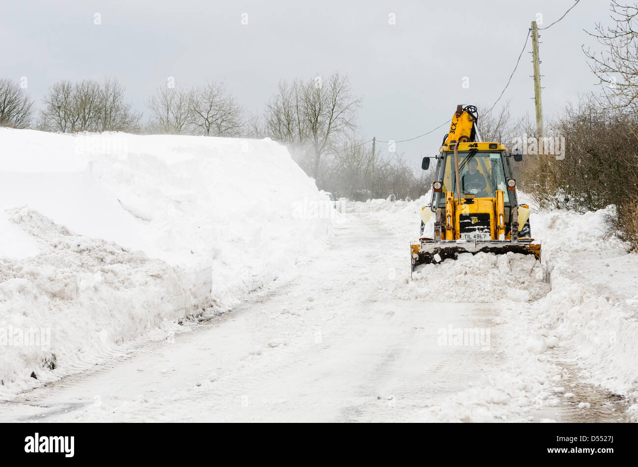 Carrickfergus, Irlanda del Nord, Regno Unito. Xxv Marzo 2013. JCBs cancellare strade colpita da derive di neve di oltre tre metri di profondità. Credito: Stephen Barnes / Alamy Live News Foto Stock