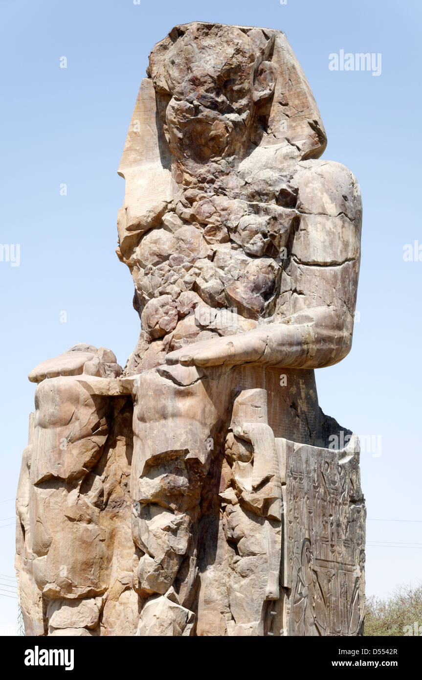 Luxor. L'Egitto. Uno dei i Colossi di Memnon, che raffigurano il faraone Amenhotep III seduto e sono situate nella necropoli tebana. Foto Stock