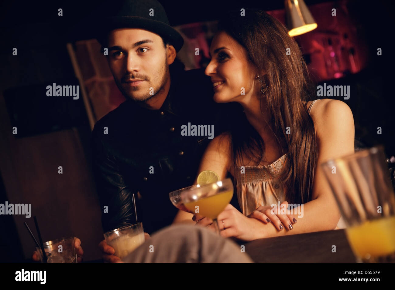 Coppia giovane godendo la loro data al bar con gli amici Foto Stock