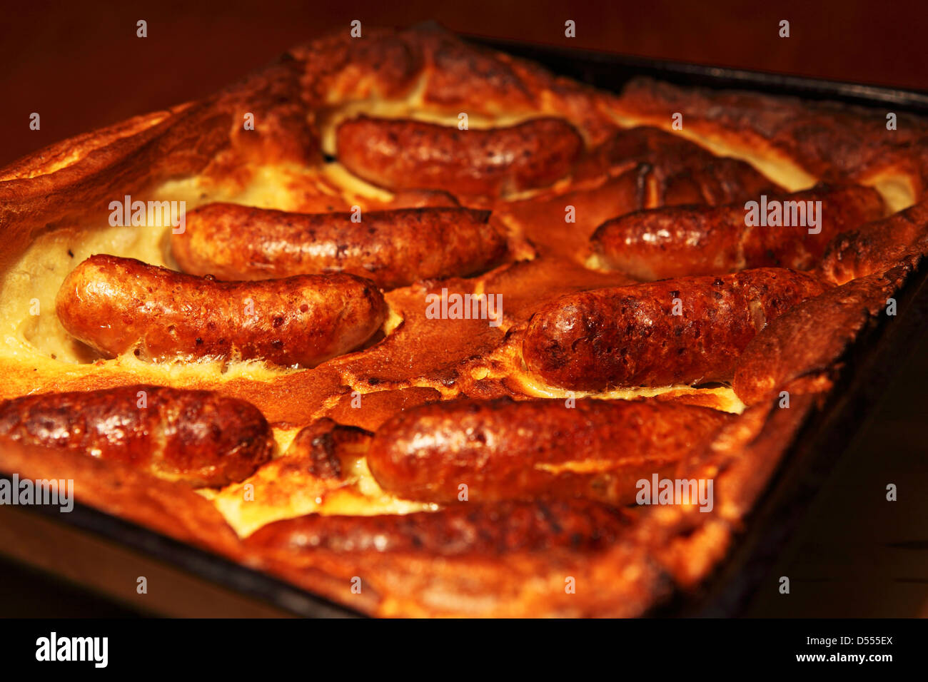 Un vassoio del classico piatto britannico Toad nel foro. Toad nel foro è fatta di salsicce in un Yorkshire pudding pastella. Foto Stock