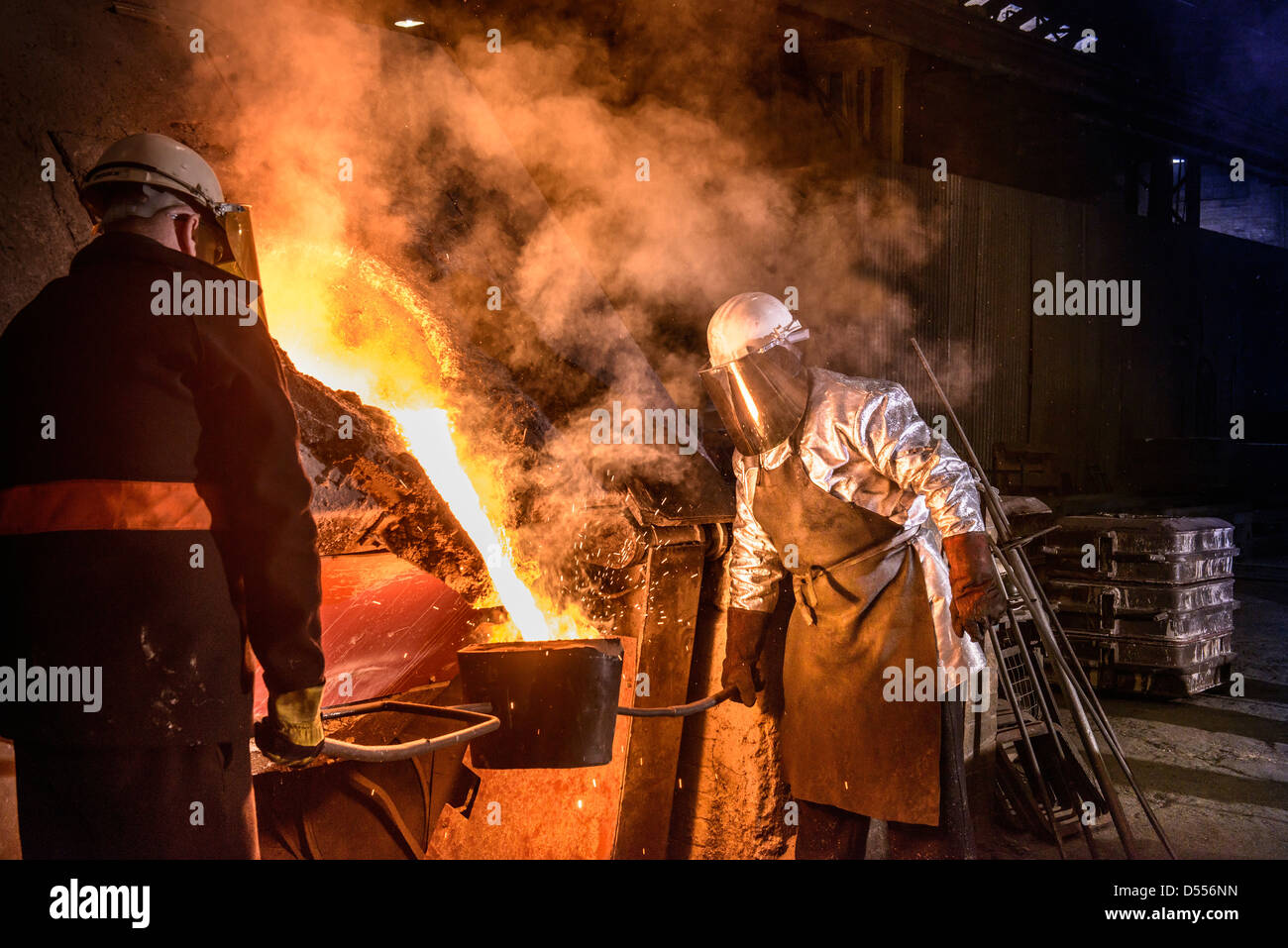 Lavoratore di colata di metallo fuso in fonderia Foto Stock