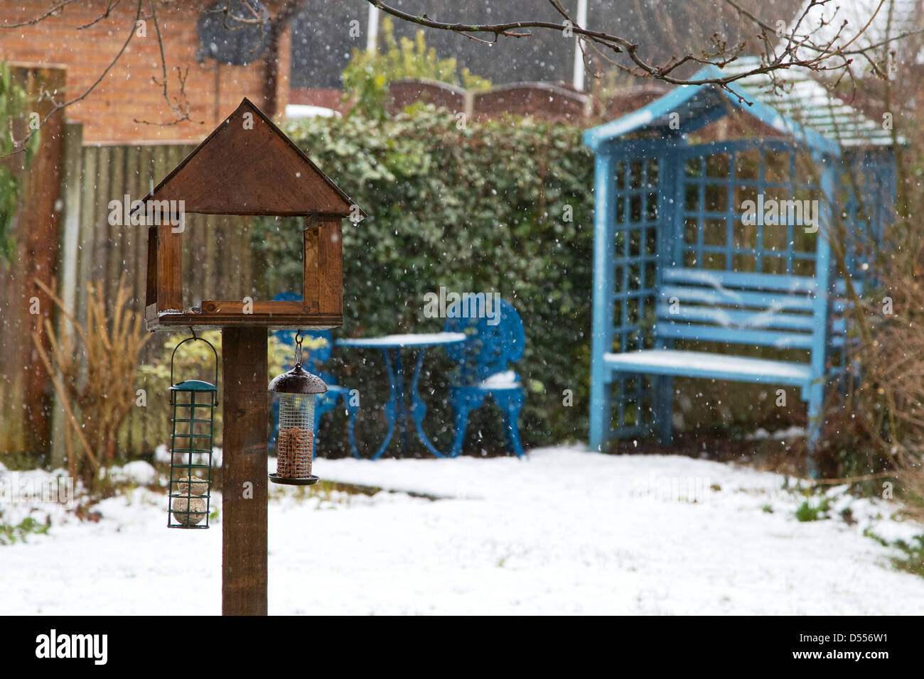 Tabella di uccelli nella neve coperto Giardino Foto Stock