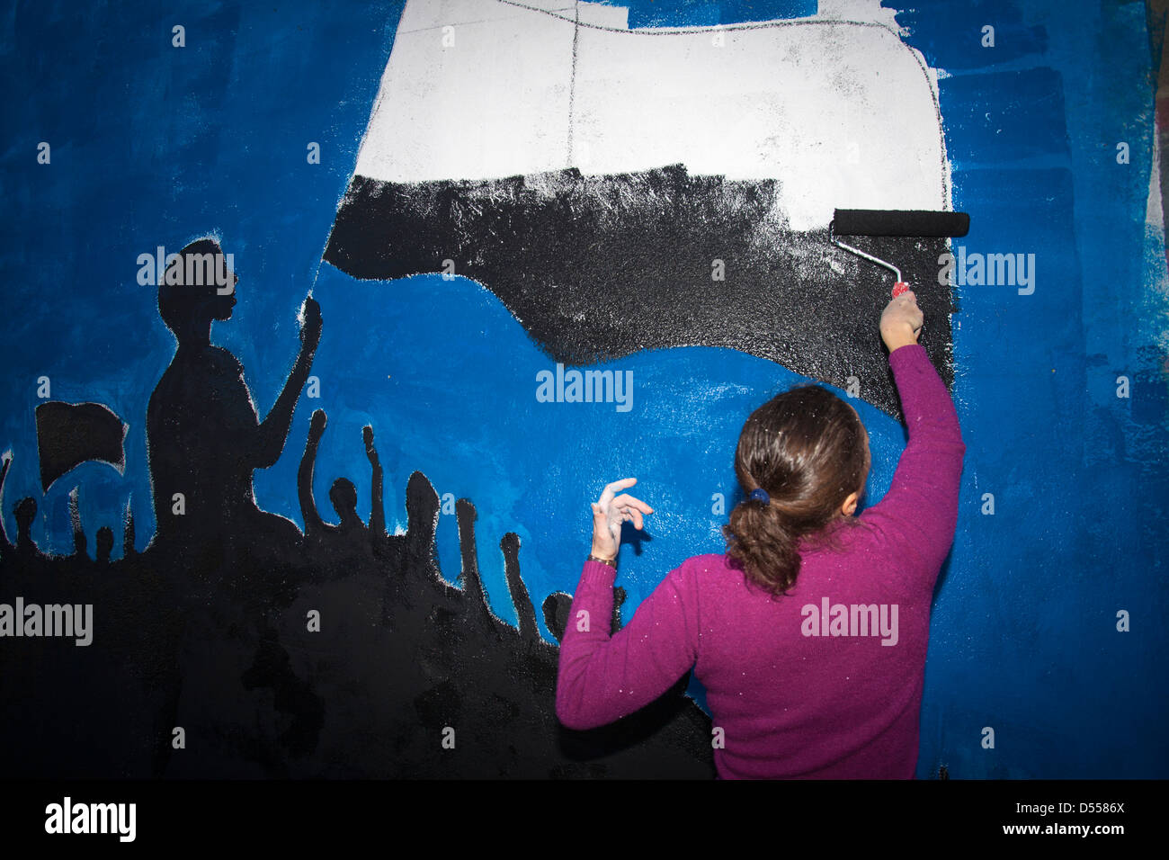 Donna dal movimento 'Accidenti Troika pittura un muro contro le misure di austerità, Lisbona, Portogallo. Foto Stock