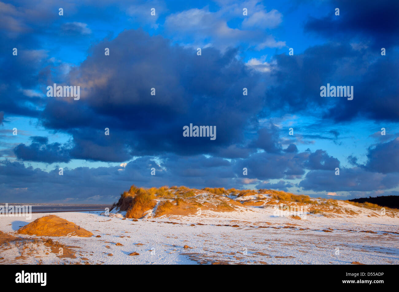 Coperta di neve dune e tramonto a Holkham spiaggia riserva naturale nazionale Norfolk Foto Stock