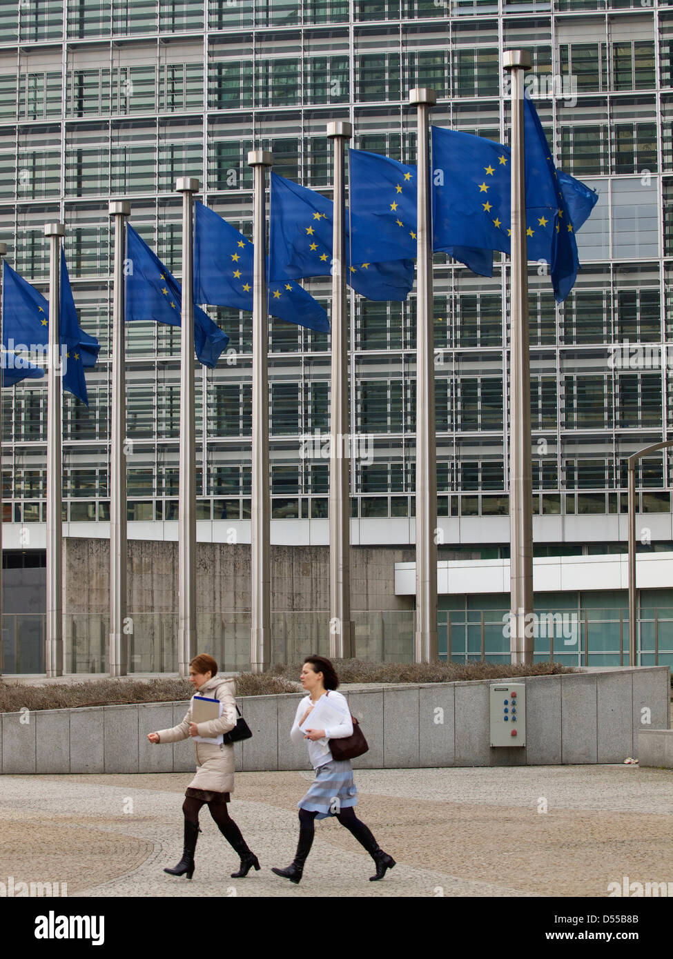 Due donne in esecuzione dall'edificio Berlaymont della Commissione europea a Bruxelles, in Belgio Foto Stock