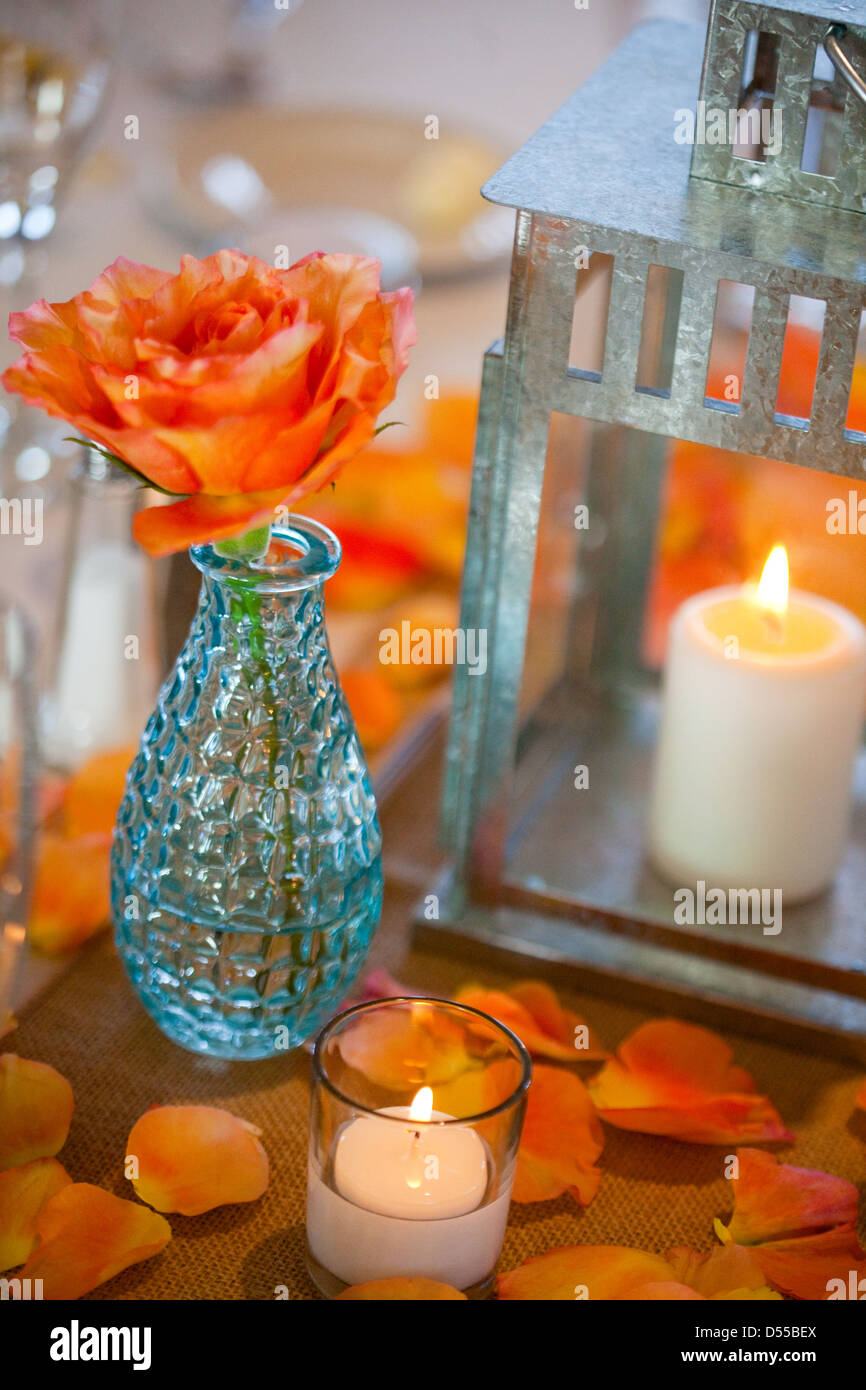 Arancione Rosa, Vaso blu, Candela, petali di rosa Foto Stock
