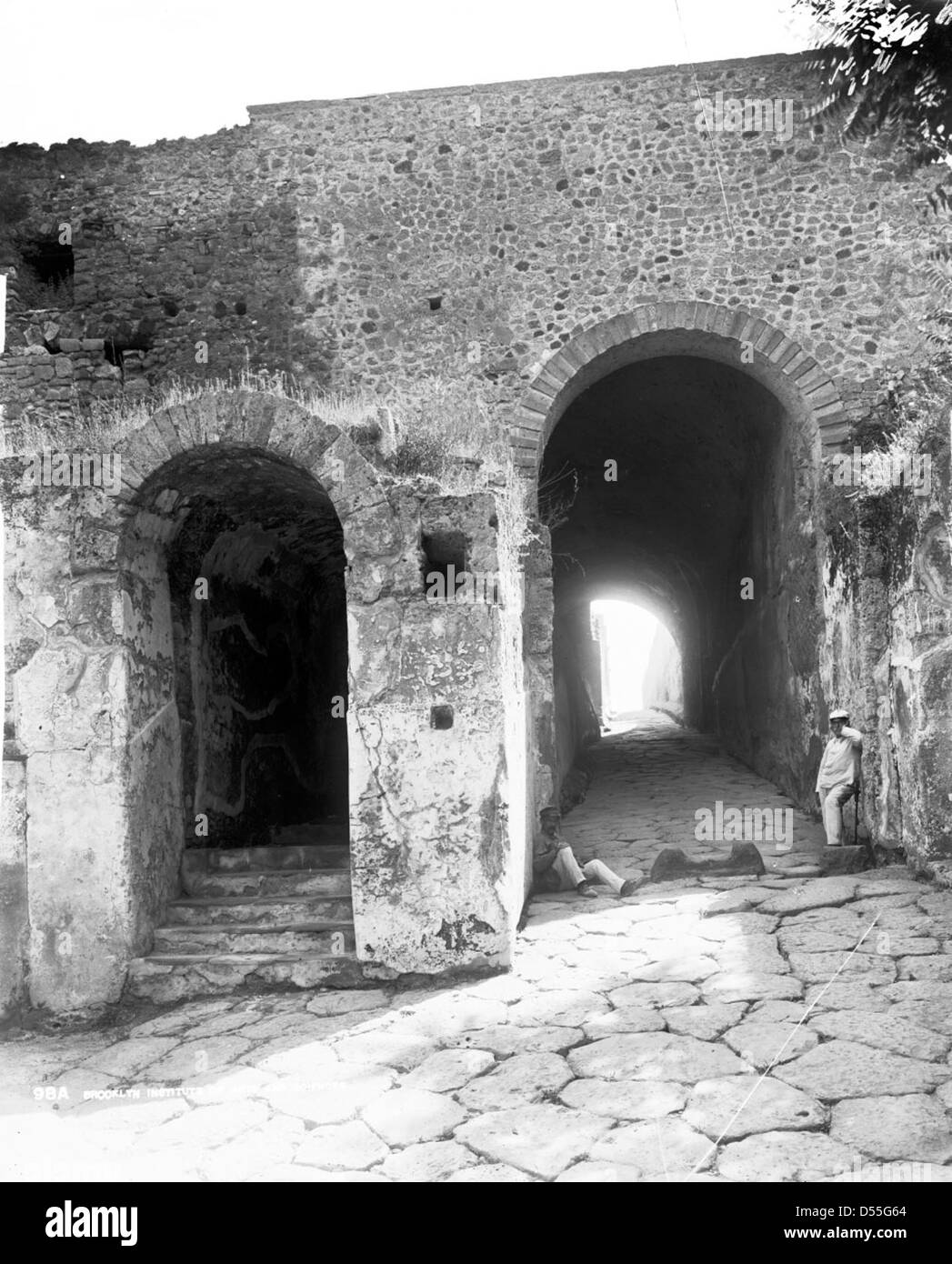 Questa fotografia cattura l'ingresso dell'antica città romana di Pompei, mostrando gli archi in pietra e i gradini in pietra che conducono al sito archeologico. Foto Stock