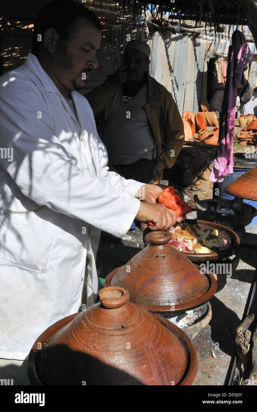 Tagine che viene cucinata in tagine di terracotta tradizionale in pentole di tagine il giorno di mercato a Jemaa D' Rehmat. A sud di Marrakech, Marocco Foto Stock