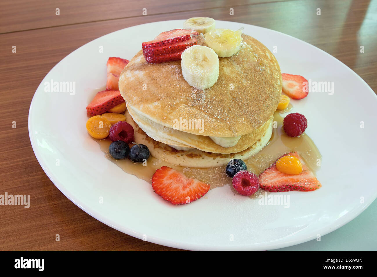 Hotcakes con mirtilli Fragole Lamponi Banana e favo di miele Foto Stock