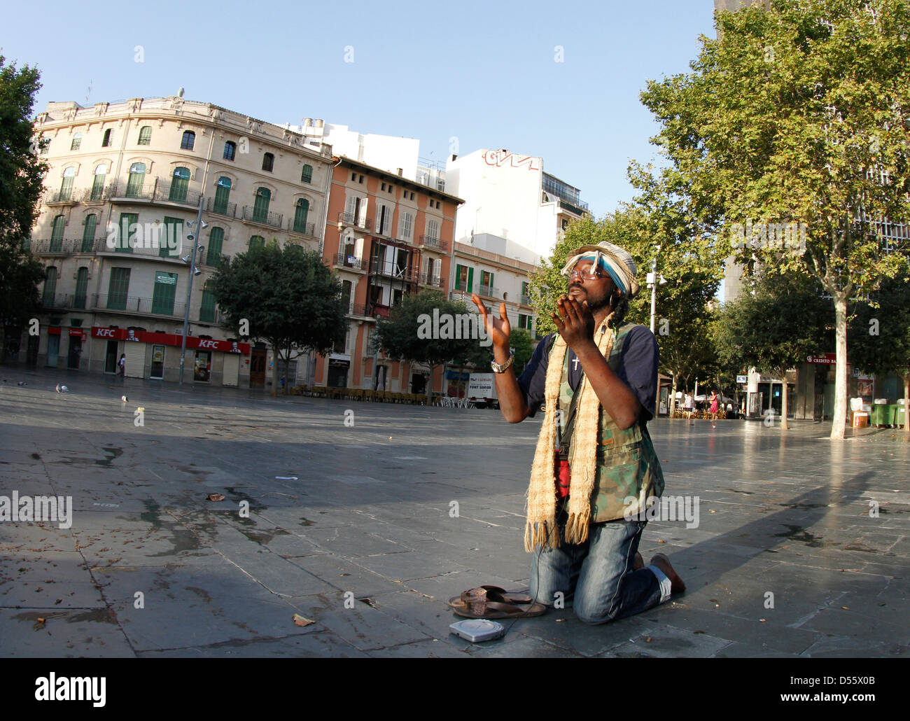 Turszy, un disoccupato e senzatetto immigrato nigeriano che spostata in Spagna nel 1997 prega su una piazza centrale di Palma Foto Stock