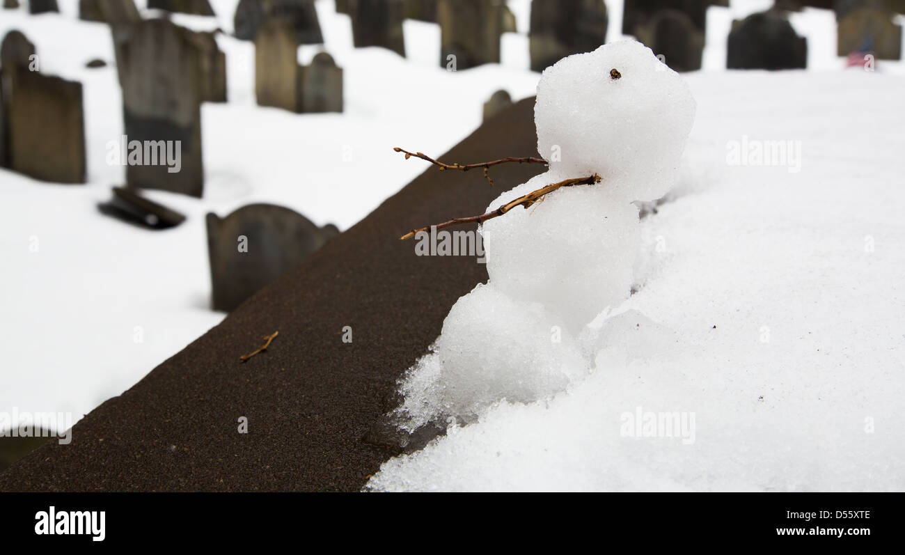 Un pupazzo di neve si siede su una tomba a granaio di seppellimento di massa in Boston. Graves visto in background. Foto Stock