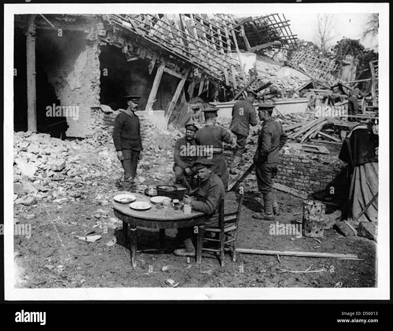 Soldati britannici ("Tommies") che cenano in un villaggio catturato durante la prima guerra mondiale. Questo momento illustra la vita quotidiana dei soldati nei territori occupati e la natura temporanea dell'occupazione militare. Foto Stock