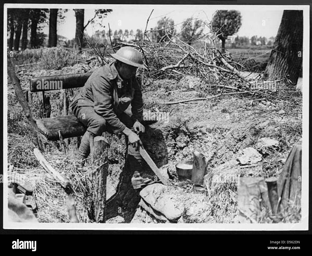 Un soldato cucina la sua cena sul campo durante la prima guerra mondiale, evidenziando le routine quotidiane e le difficoltà affrontate dalle truppe nelle trincee. Foto Stock