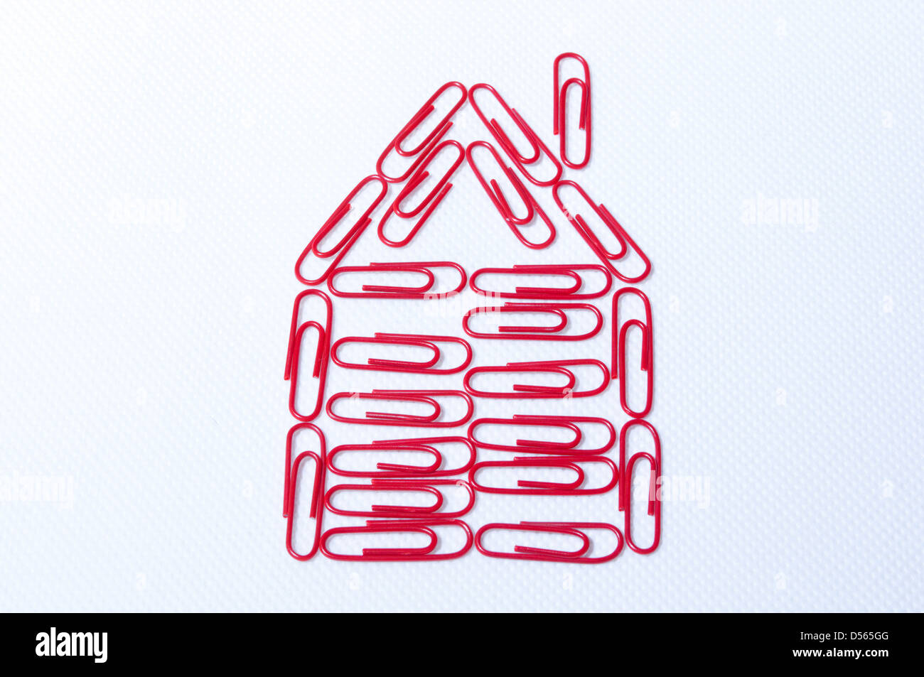 Progettare una casa con carta rossa fermi sullo sfondo bianco Foto Stock
