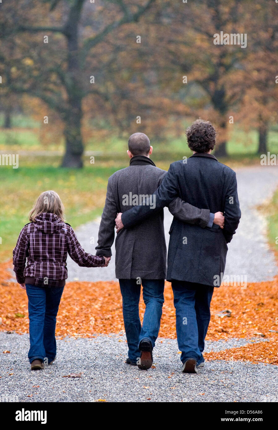 Una famiglia di due uomini gay e la loro figlia andare per una passeggiata a giardini di Herrenhaeuser ad Hannover, Germania, 4 novembre 2010. La famiglia idilliaca vita sembra perfetto in una costellazione di padre e di madre e bambino. Ma allora il padre scende e viene fuori come gay. Il modello di due padri in non più rare. A livello nazionale vive un numero di circa 200 000 fino tp 300 000 gay padri un Foto Stock
