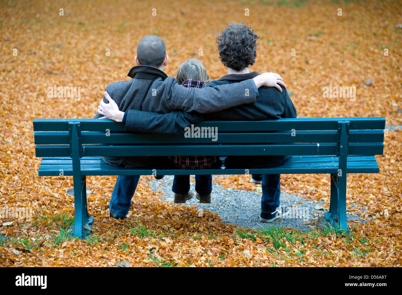 Una famiglia di due uomini gay e la loro figlia a sedersi su una panchina nel parco presso i giardini di Herrenhaeuser ad Hannover, Germania, 4 novembre 2010. La famiglia idilliaca vita sembra perfetto in una costellazione di padre e di madre e bambino. Ma allora il padre scende e viene fuori come gay. Il modello di due padri in non più rare. A livello nazionale vive un numero di circa 200 000 fino tp 300 000 gay fath Foto Stock
