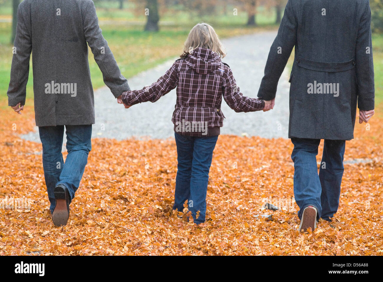 Una famiglia di due uomini gay e la loro figlia andare per una passeggiata a giardini di Herrenhaeuser ad Hannover, Germania, 4 novembre 2010. La famiglia idilliaca vita sembra perfetto in una costellazione di padre e di madre e bambino. Ma allora il padre scende e viene fuori come gay. Il modello di due padri in non più rare. A livello nazionale vive un numero di circa 200 000 fino tp 300 000 gay padri un Foto Stock