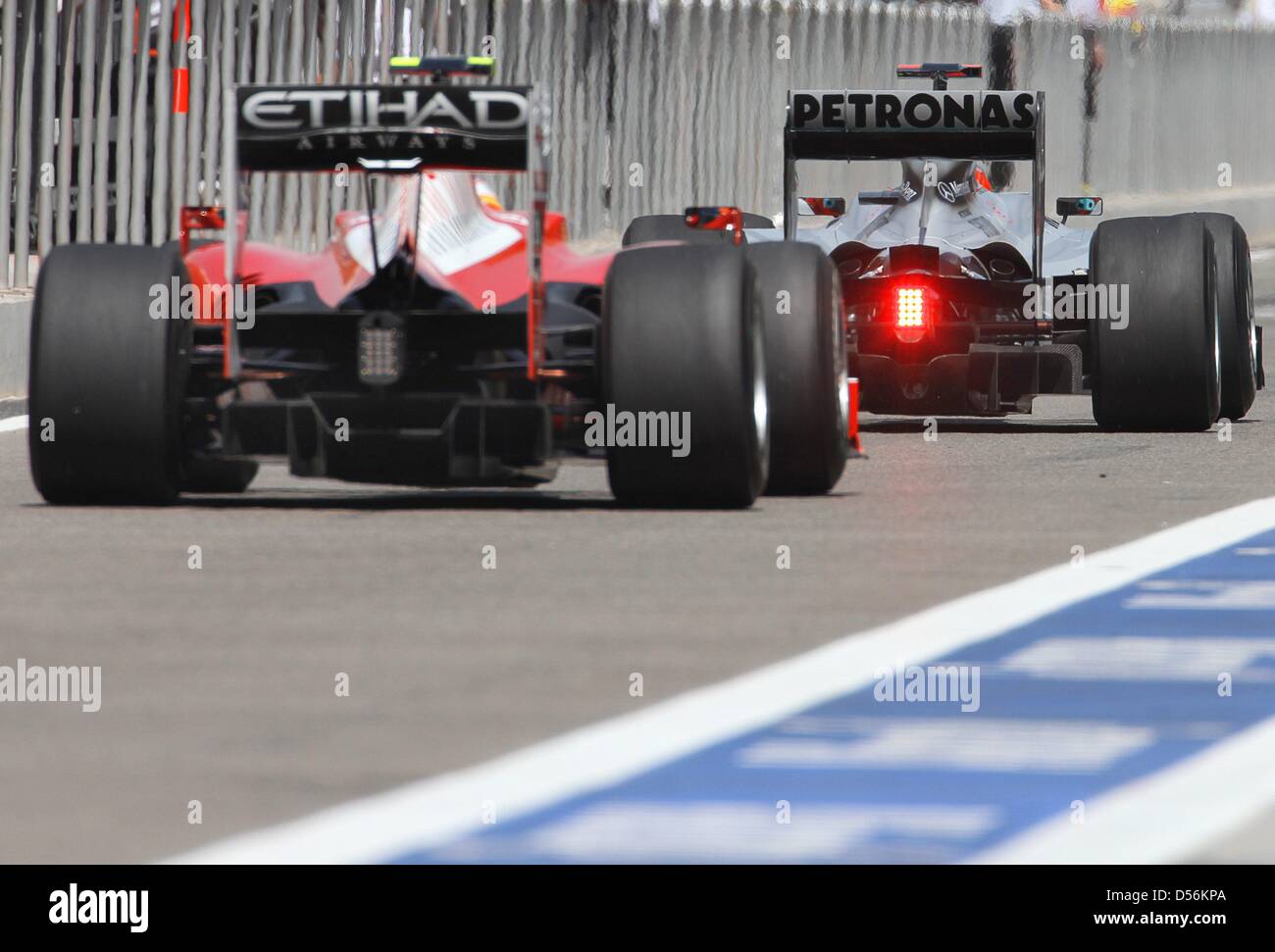 Il tempo di sette di Formula Uno del campione del mondo in carica Michael Schumacher (R) e il Brasiliano racing driver Felipe Massa (Ferrari) guidare attraverso la pit lane durante la terza formazione a Sakhir la pista in Bahrain, 13 marzo 2010. Il Gran Premio del Bahrain inaugura il 2010 Formula Uno Stagione. Foto: Jens BUETTNER Foto Stock