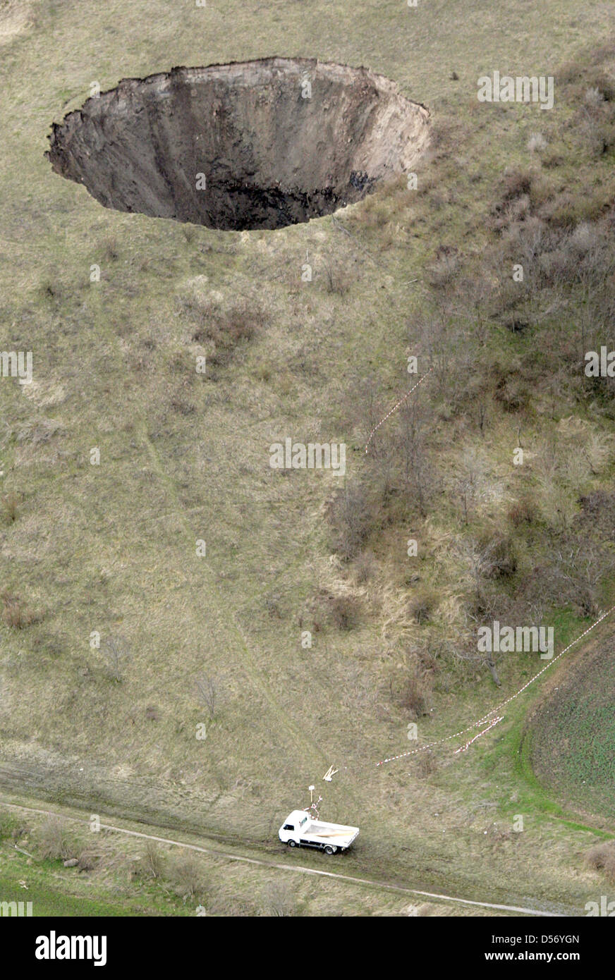 Una cupola di sale è collassato sotto una chiusa sito per lo smaltimento dei rifiuti e ha strappato un grande buco nella terra vicino a Bernburg, Germania, 01 aprile 2010. La zona circostante il foro era recintata con funi, è di circa 40 metri di profondità ed ha un diametro di circa trenta metri. Gli esperti ivestigations iniziato il 01 aprile. Non è chiaro se vi sia una minaccia di ulteriori crolli. Foto: Jens WOLF Foto Stock