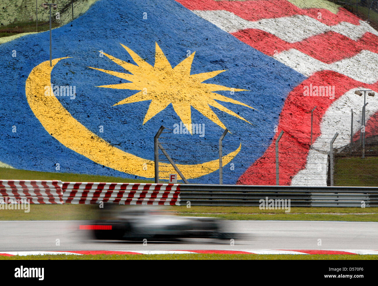 La Gran Bretagna è pilota di Formula Uno Jenson Button alla McLaren Mercedes manzi il suo racecar superato la nazionale malese bandiera a racetrac a Sepang vicino a Kuala Lumpur, Malesia, 03 aprile 2010. Con il GP di Malesia sul le vacanze di Pasqua Fine settimana la terza gara di Formula Uno Stagione 2010 inizia a. Foto: Jens Buettner Foto Stock