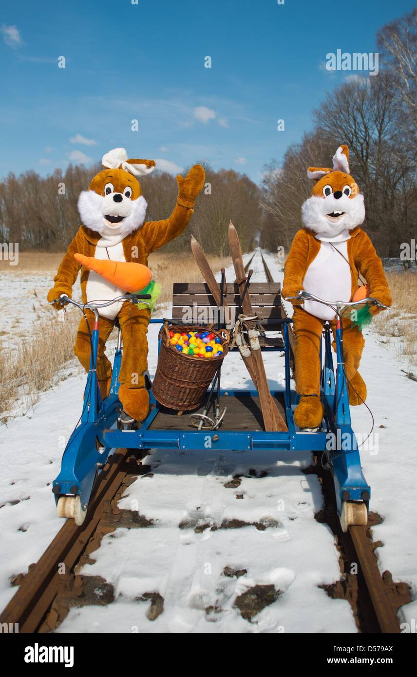 Mellensee, Germania. 26 marzo, 2013. Una illustrazione mostra due persone che indossano Easter Bunny costumi su una rotaia-cycle draisina al chiuso ferroviaria di divertimenti in Mellensee, Germania, 26 marzo 2013. Il coniglietto di Pasqua si nascondono le uova lungo la ex "Royal militare prussiano ferrovia per i turisti di trovare nel quartiere Teltow-Flaeming sulla Pasqua. Foto: PATRICK PLEUL/dpa/Alamy Live News Foto Stock