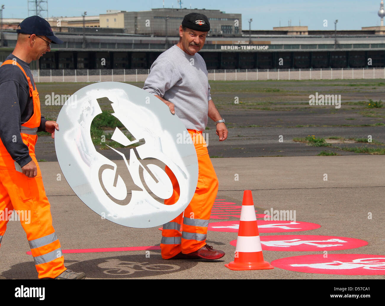 I membri dello staff di una strada in costruzione company mark corsie di ciclisti, pattinatori e pedoni il chiuso aeroporto Tempelhof di Berlino, Germania, 05 maggio 2010. Grandi parti del vecchio aeroporto sarà aperto al pubblico il prossimo fine settimana, tra cui sport e giocare a cantieri e aree barbecue. Il terminal passeggeri (retro) è sotto tutela monumentale e non saranno aperti fo Foto Stock