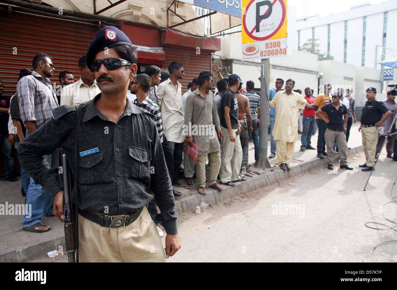 Ufficiali di polizia avviso stand durante la manifestazione di protesta di funzionari di polizia contro la mancata disponibilità di loro a causa degli stipendi, al di fuori della sede centrale della polizia a I.I.Chundrigar road a Karachi. Foto Stock