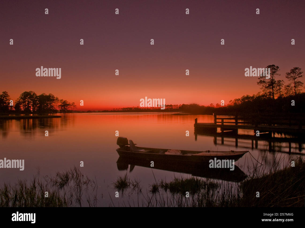 Fine arancione tramonto su acque calme con riflessioni. Ceder punto NC. Stati Uniti d'America Foto Stock