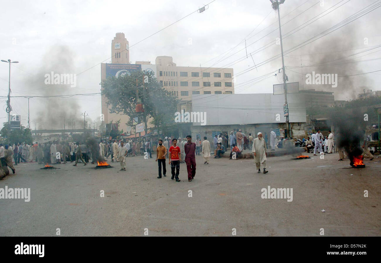 Manifestanti arrabbiati bruciare pneumatici stradali di blocco durante la manifestazione di protesta dei residenti di Kharadar contro il funzionamento mirato dai rangers funzionari, in area torre a Karachi. Foto Stock