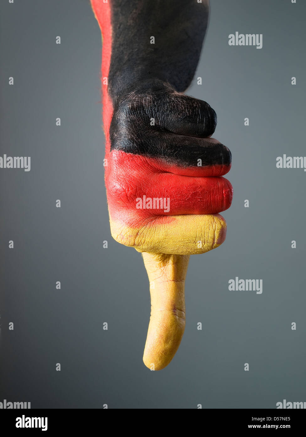 Dipinta a mano con la bandiera della Germania, esprimendo la negatività e isolate su uno sfondo grigio Foto Stock