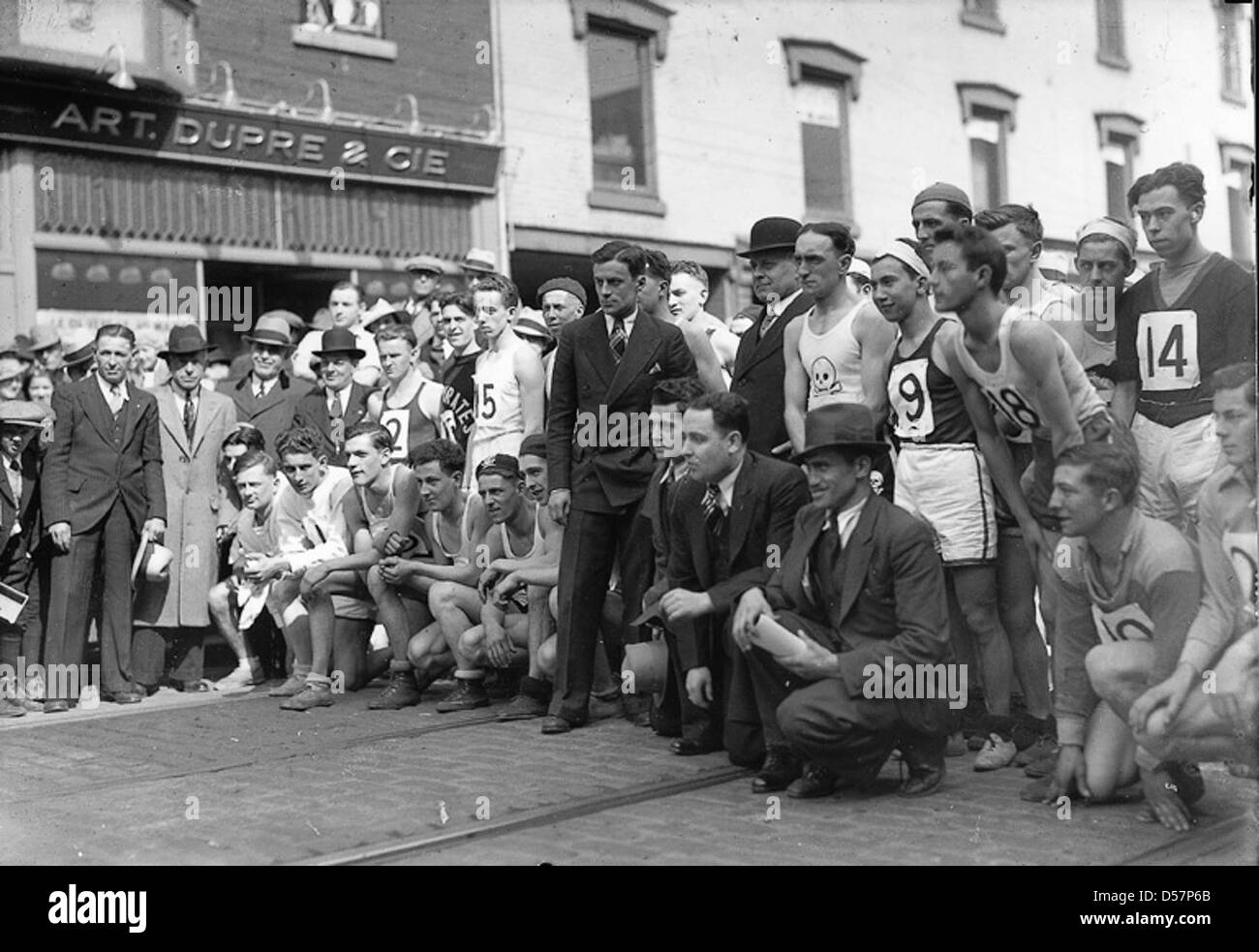 Questa fotografia cattura l'inizio di una gara a Montreal, Quebec, intorno al 1930. L'immagine mostra i concorrenti allineati alla linea di partenza, riflettendo la popolarità degli eventi di corse nel Canada dei primi anni del XX secolo. Foto Stock