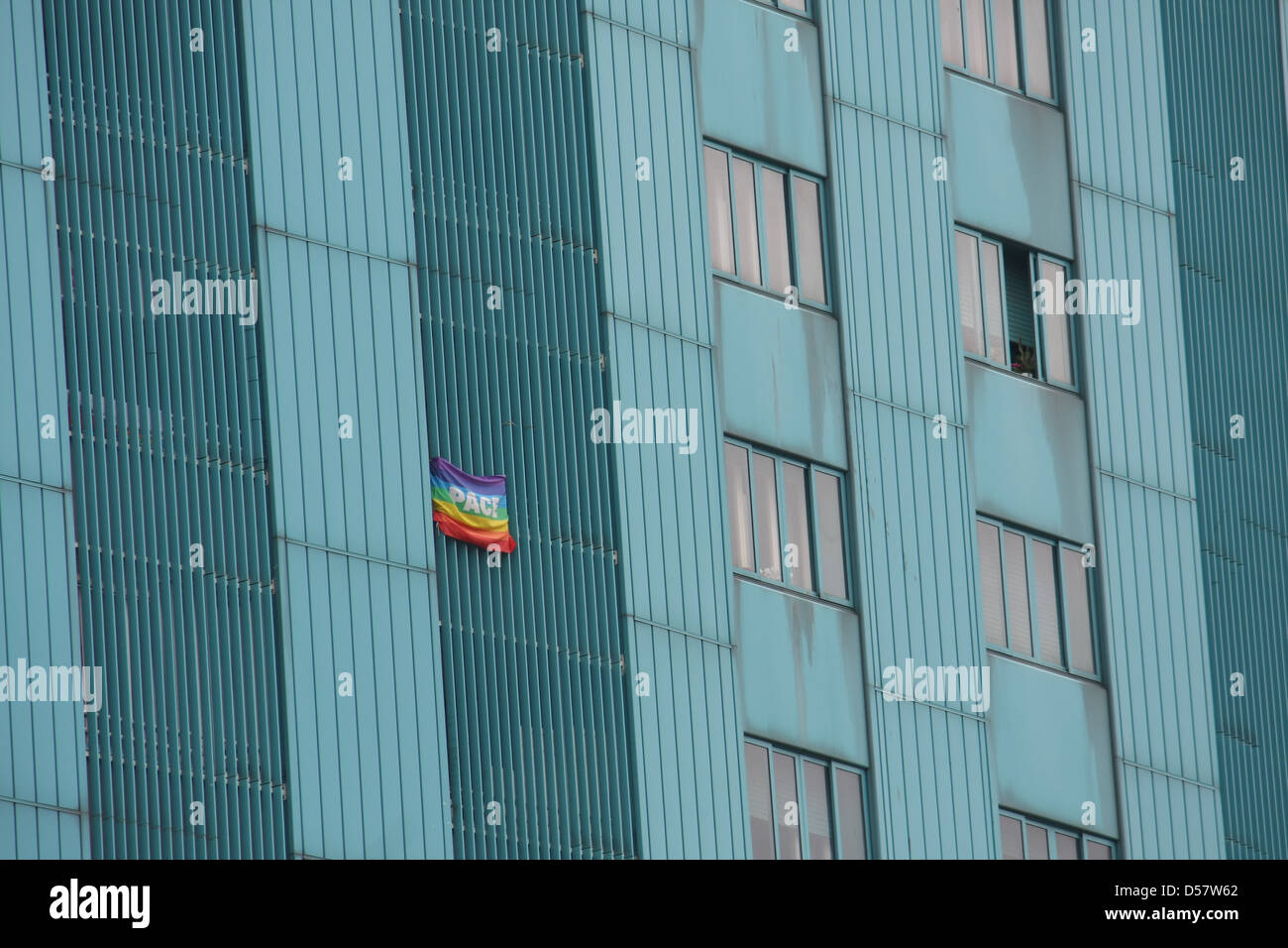 Bandiera della pace appeso un enorme condominio grattacielo in metropoli italiana Foto Stock