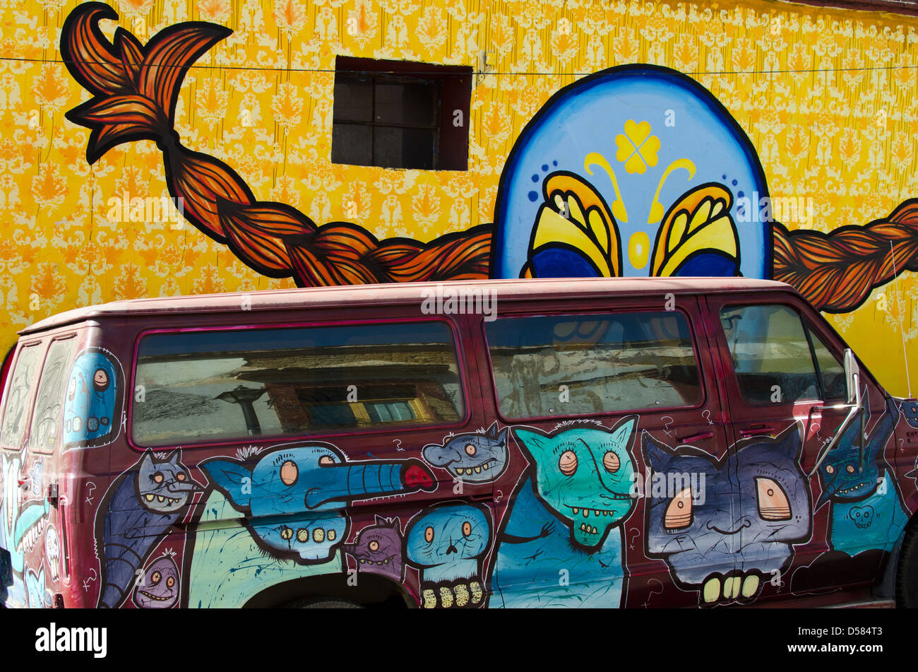 Un furgone coperto in mostri dipinte dall'artista SCOM è parcheggiato di fronte un murale da Kollektivet Livet in Oaxaca, Messico. Foto Stock