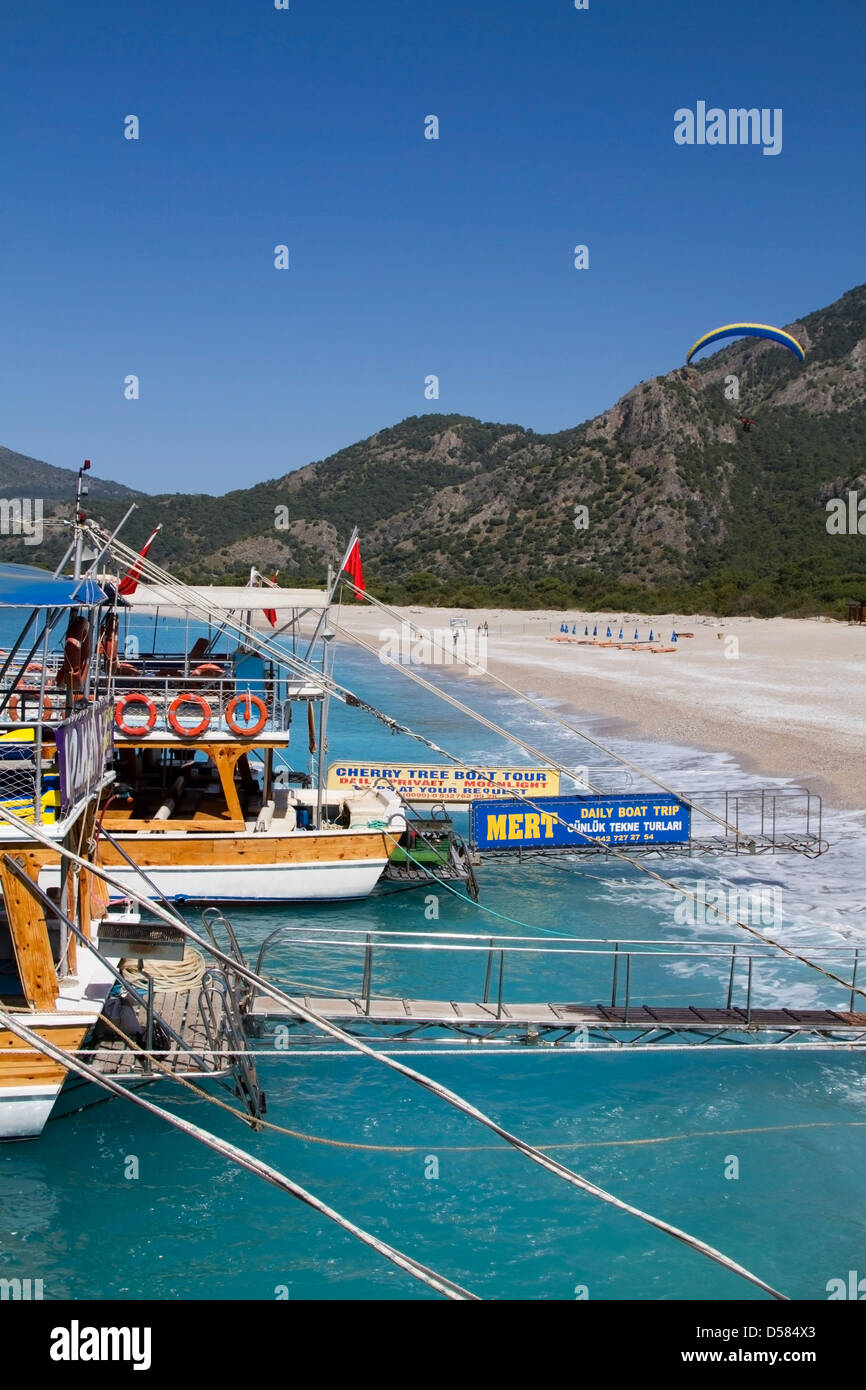 Le imbarcazioni turistiche e un parapendio a Oludeniz beach - Turchia Foto Stock