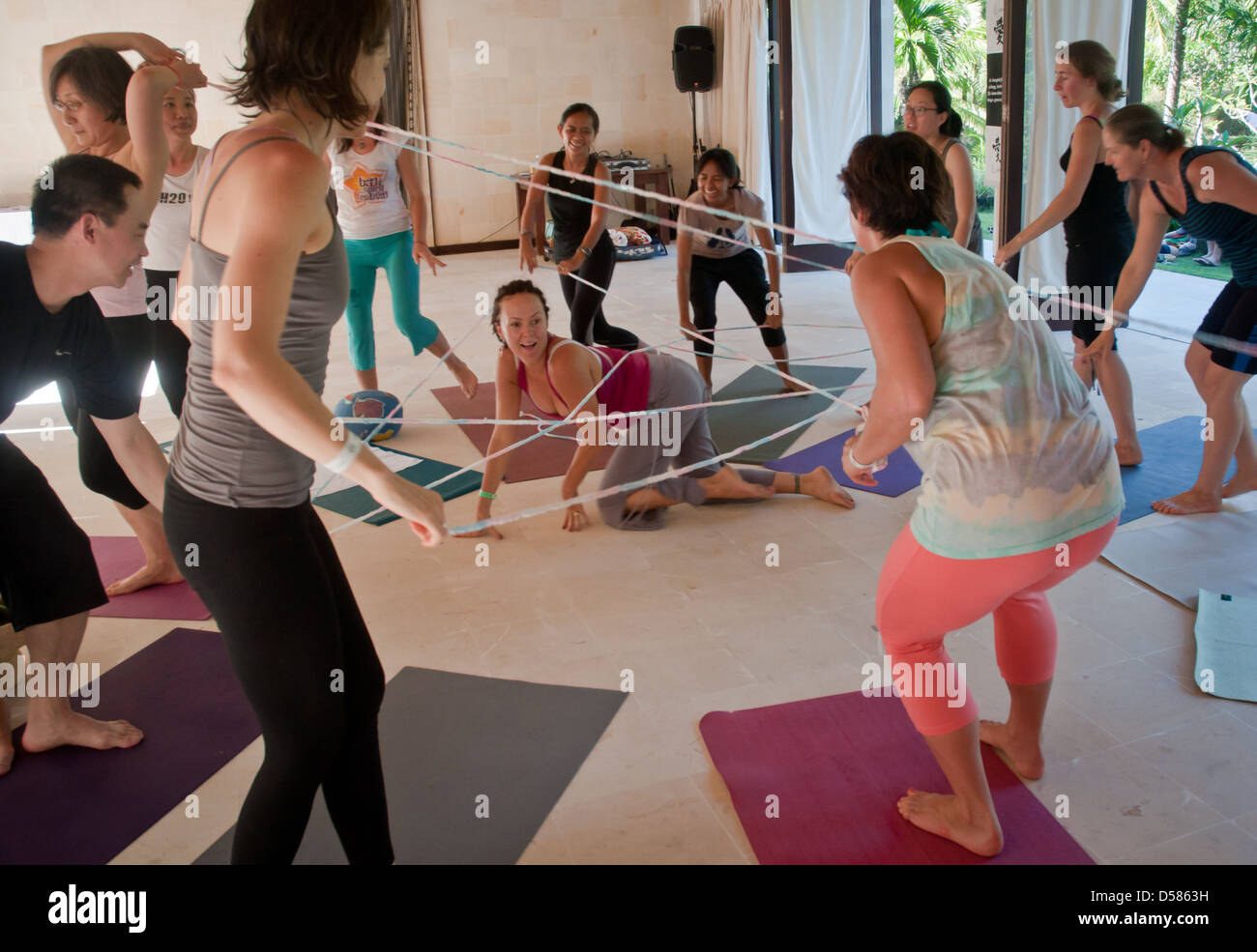 Bali, Indonesia-marzo 20, 2013: le righe di maschio e femmina adulti, giacente su tappeti colorati in una classe di yoga a Bali spirito Festival. Foto Stock