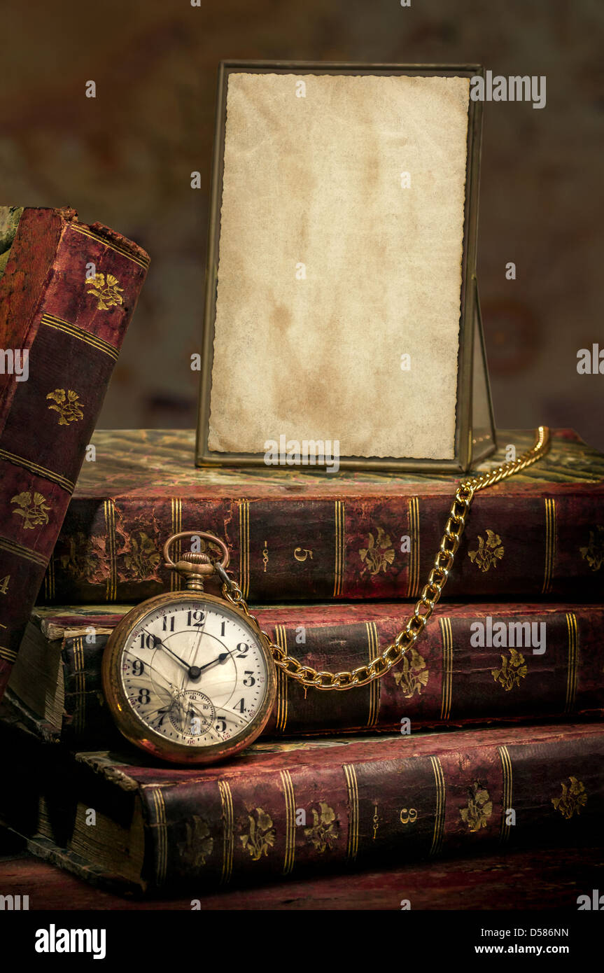 Il telaio con la vecchia carta fotografica texture, orologio da tasca e libri in basso-chiave Foto Stock