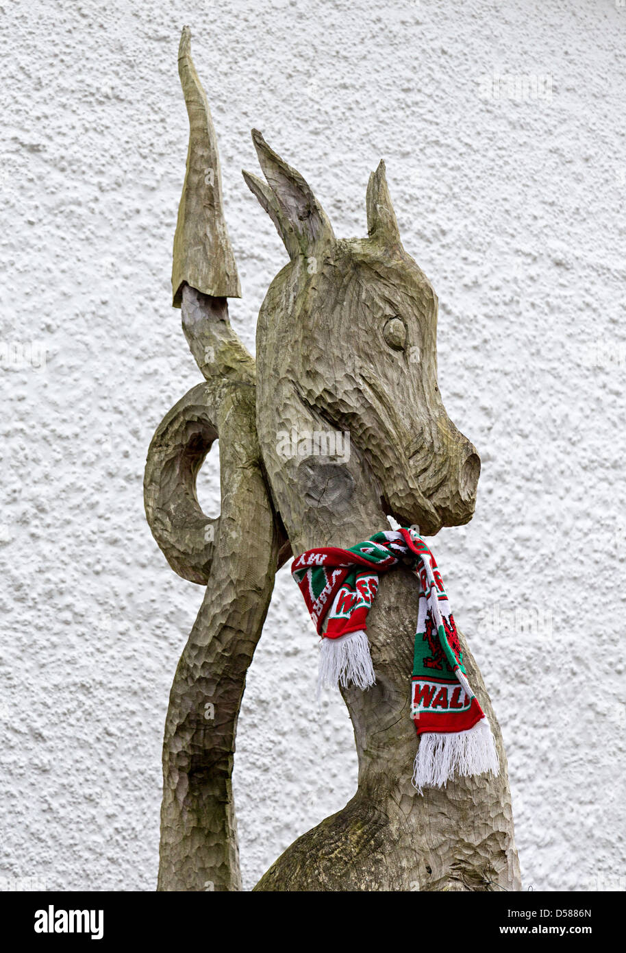 Legno intagliato Welsh dragon indossando un Galles sciarpa, Llanfoist, Wales, Regno Unito Foto Stock