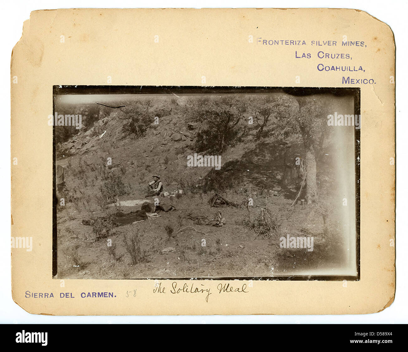 Questa fotografia raffigura un pasto solitario consumato da un uomo in un campeggio sulle Coahuila Hills vicino a Las Cruces, in Messico. Offre un momento tranquillo e intimo in mezzo al paesaggio aspro. Foto Stock