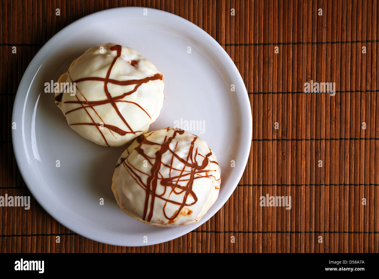 Gustose ciambelle al cioccolato sulla piastra bianca su un tavolo da cucina. Dolce cibo malsano. Foto Stock